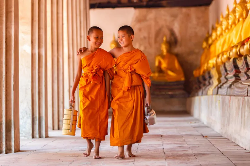Zwei junge Mönche laufen durch einen Tempel