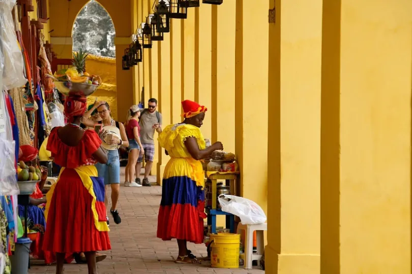Frauen in bunten Kleidern verakufen Früchte in Cartagena