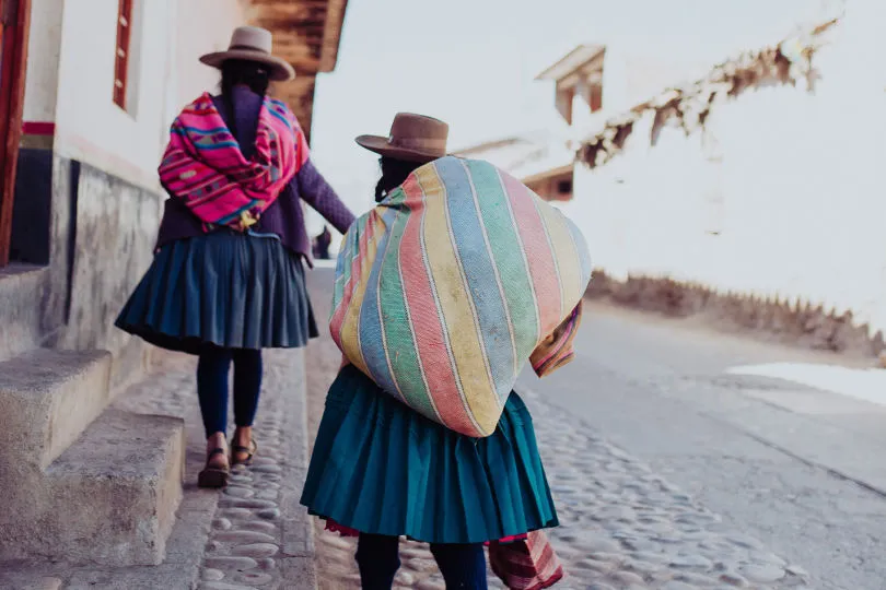 Zwei Frauen laufen in Cusco eine Straße entlang