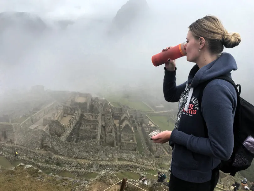 Plastikreporterin Lisanne steht in Peru an einer Ruine und trinkt aus ihrer wiederverwendbaren Trinkflasche