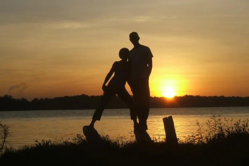Zwei Menschen stehen im Sonnenuntergang