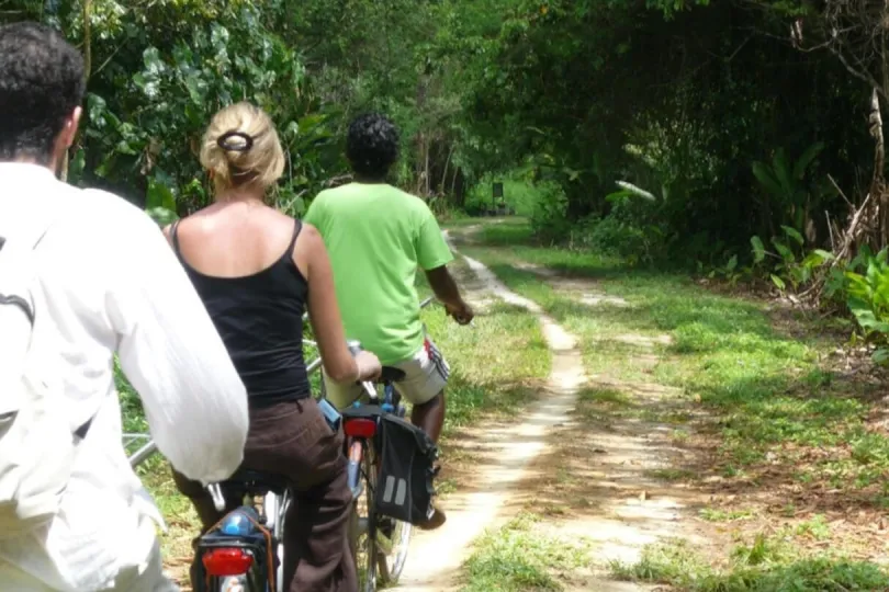 Drei Menschen fahren Fahrrad in Suriname
