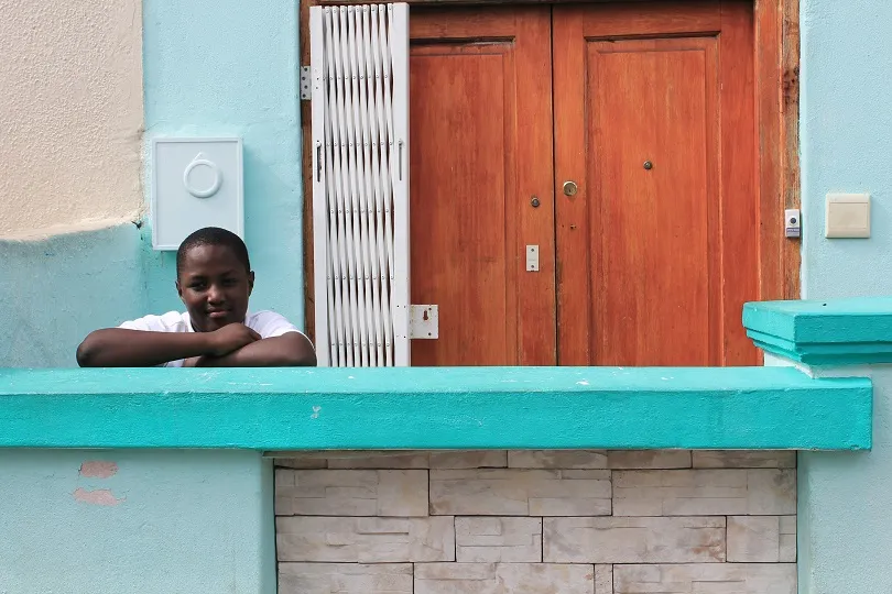 Ein Junge vor einer bunten Hausfront in Kapstadt