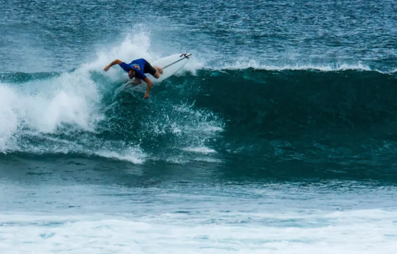 Ein Surfer in den Wellen am Hikkaduwa Strand