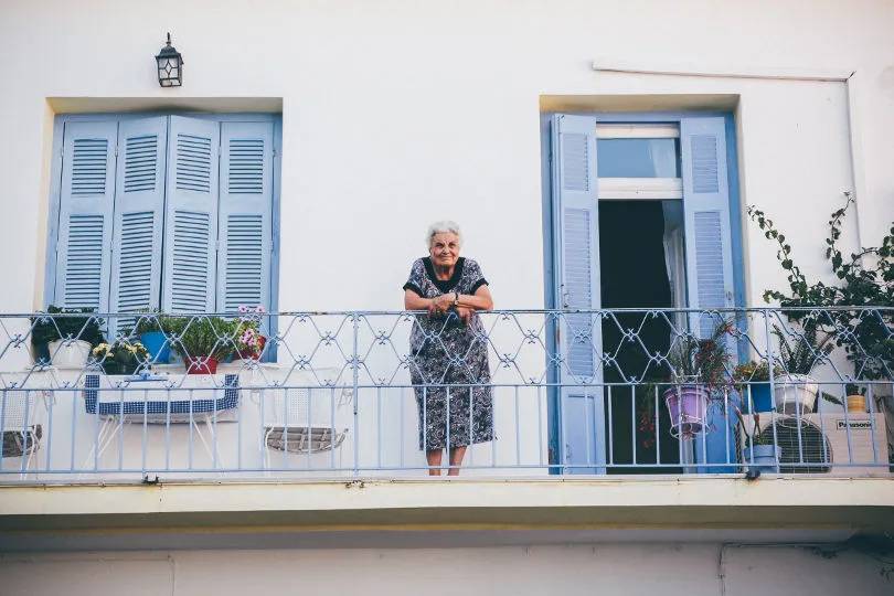 Eine Frau steht auf einem Balkon in Griechenland