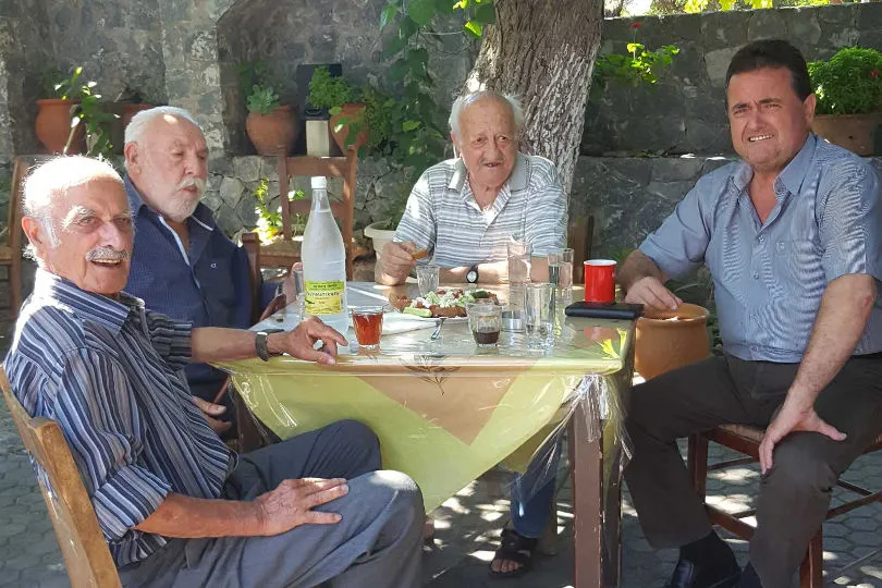 Vier Männer sitzen an einem Tisch zusammen auf Kreta