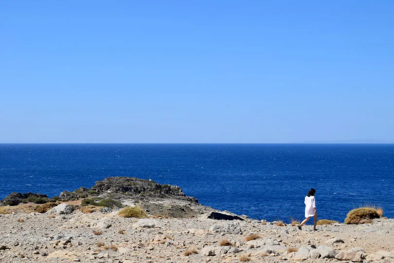 Eine Frau spaziert an einem Strand in Kreta