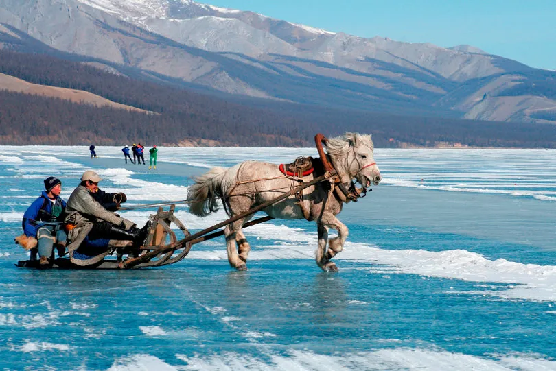 Ein Schlitten fährt über einen zugefrorenen See während eines mongolischen Festes