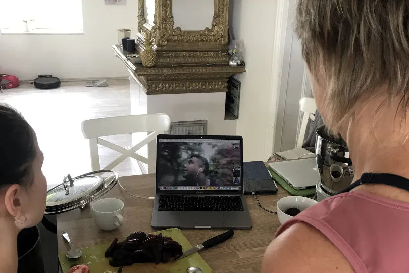 Zwei Frauen stehen vor dem Computer, um gemeinsam mit Angelo zu kochen