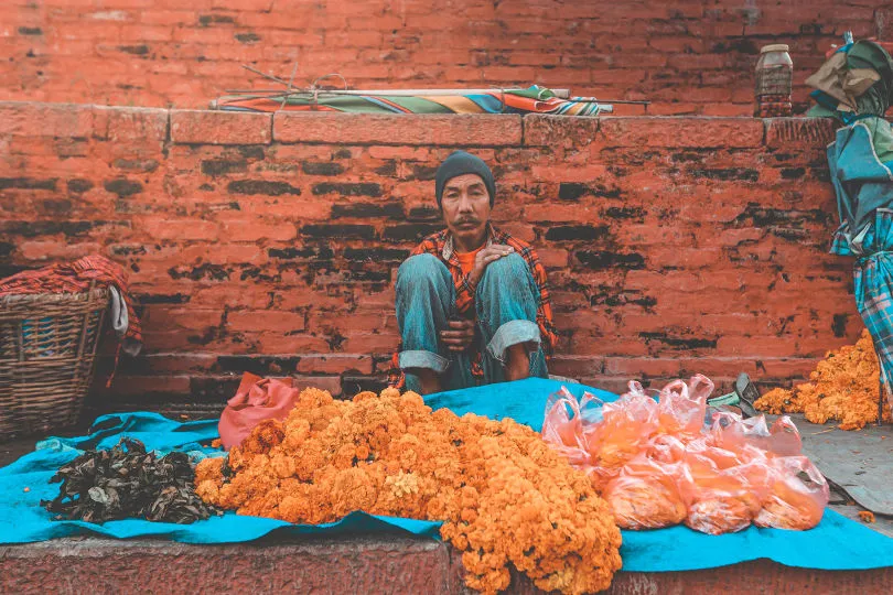 Ein Mann sitzt in Nepal auf einem Markt