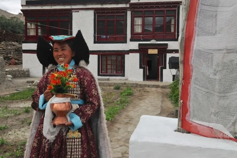 Eine Frau empfängt Familien herzlich auf der Reise nach Ladakh