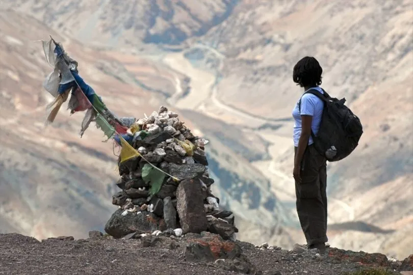 Eine Frau steht auf einem Berg während der Ladakh Familienreise