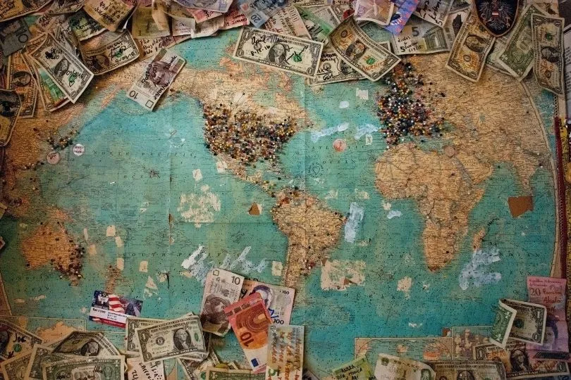 Geldscheine liegen auf einer Weltkarte