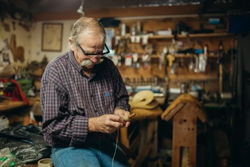 Ein Mann bei der Herstellung einer Flöte