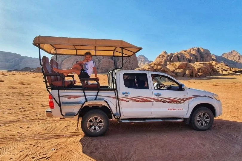 Anas sitzt auf einem Jeep während der Familienreise durch Jordanien