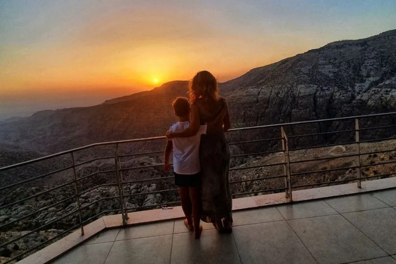 Nina und Anas stehen bei der Familienreise in Jordanien und bestaunen den Sonnenuntergang