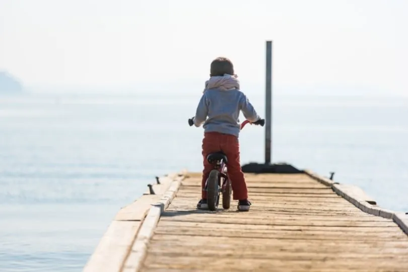 Ein Kleinkind in Sardinien mit Laufrad