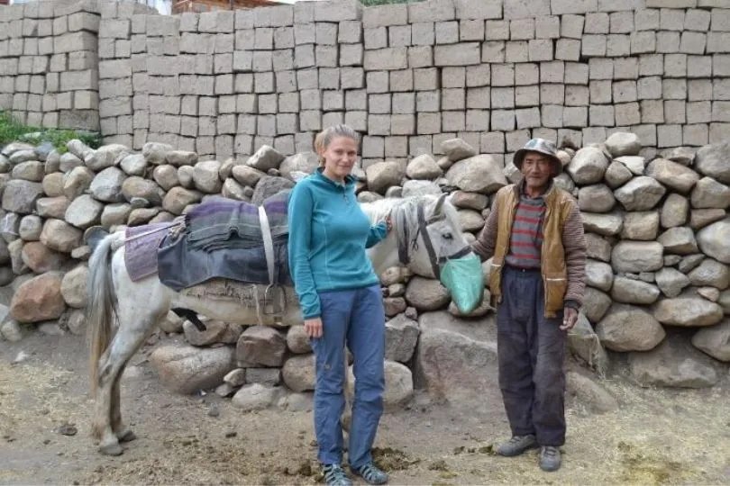Natascha steht bei einem Pferd und einem Einheimischen in Ladakh