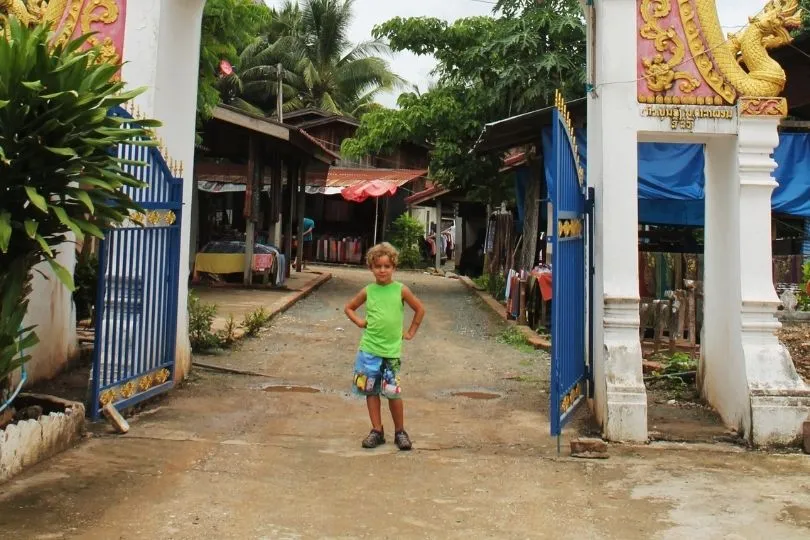 Ein Junge während dem Laos Urlaub vor einem Tempel