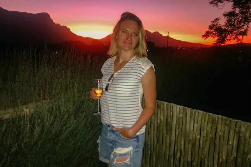 Dörte, Reisecoachin, mit einem Glas Wein bei einem Sonnenuntergang