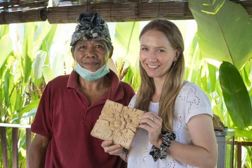 Anna steht neben einem indonesischen Künstler bei dem Holzschnitzerei Kurs