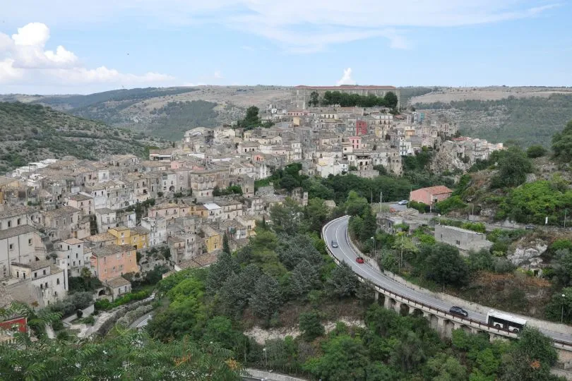 Eine Straße führt in eine Stadt in Sizilien