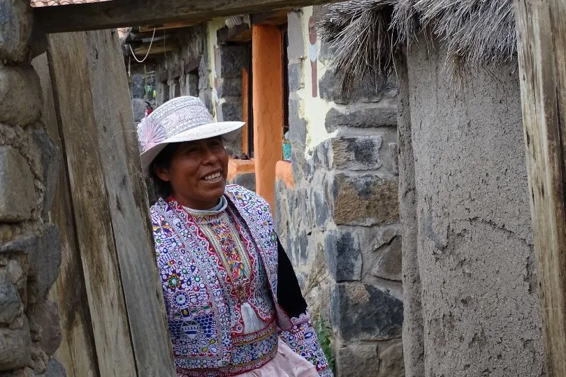 Eine Frau schaut aus einem Eingang heraus im Colca Canyon in Peru