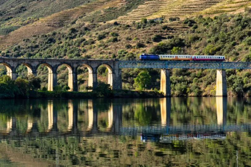Zug auf historischer Brücke in Portugal während der Rundreise mit dem Auto