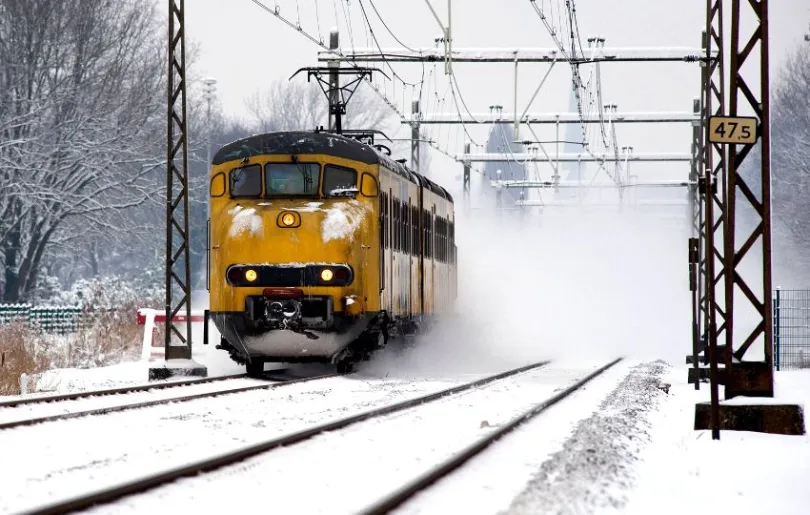 gelber Zug fährt durch den Schnee