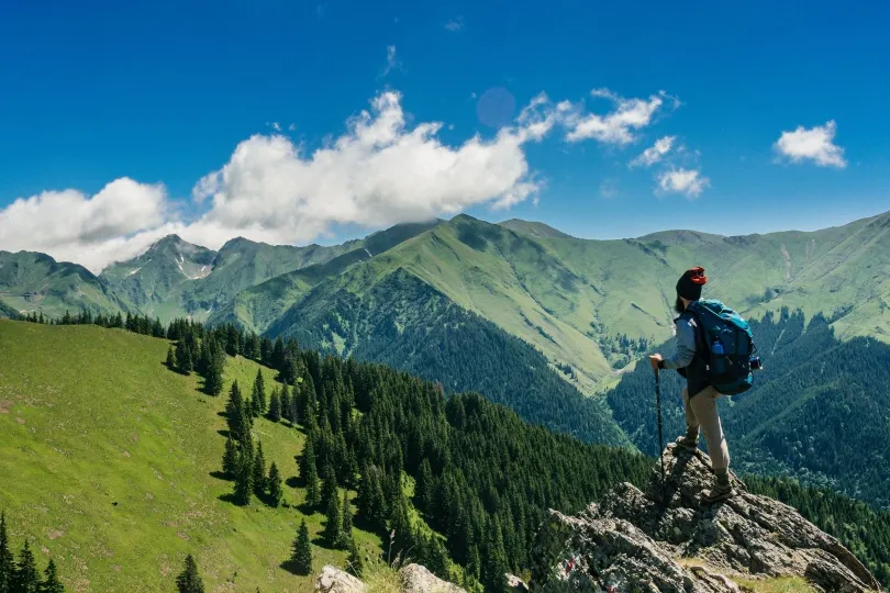 Ein Mann sitzt während seiner Rumänien Reise in der Landschaft.