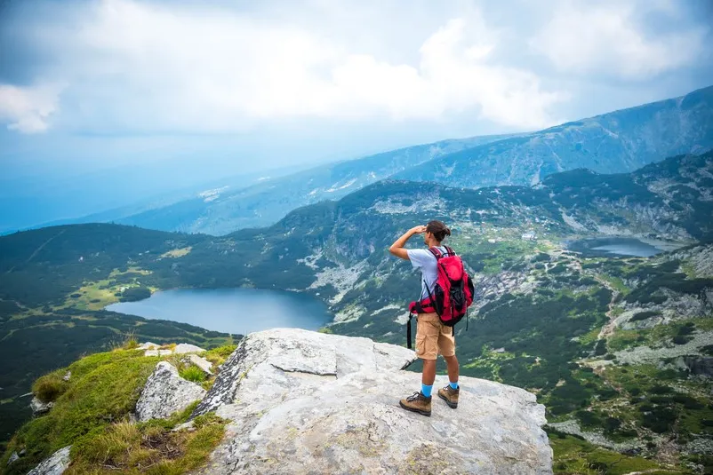 Ein Mann auf einem Felsen mit Aussicht.