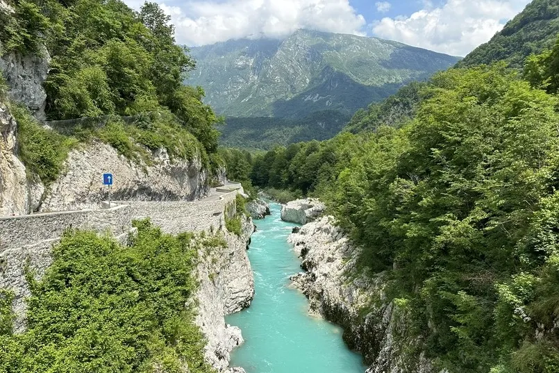 Fluß mit klargrüner Farbe und Bergen in Slowenien.