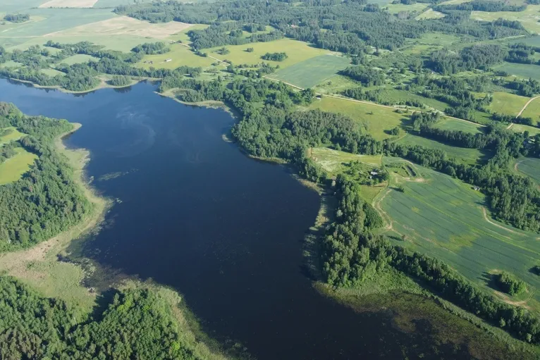 Luftaufnahme auf einen Nationalpark in Lettland. Hier gibt große grüne Wiese und einen Fluß.