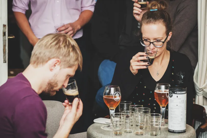 Ein Mann und eine Frau riechen Bier. 