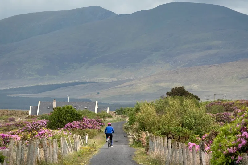 Eine Frau fährt mit dem Rad in Great Western Greenway, Irland.