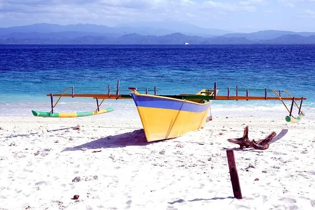 Fischerboot am weißen Tropenstrand.