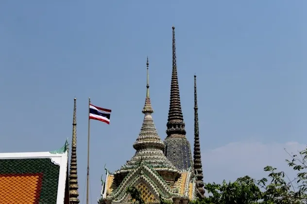 Tempelspitzen mit thailändischer Flagge.