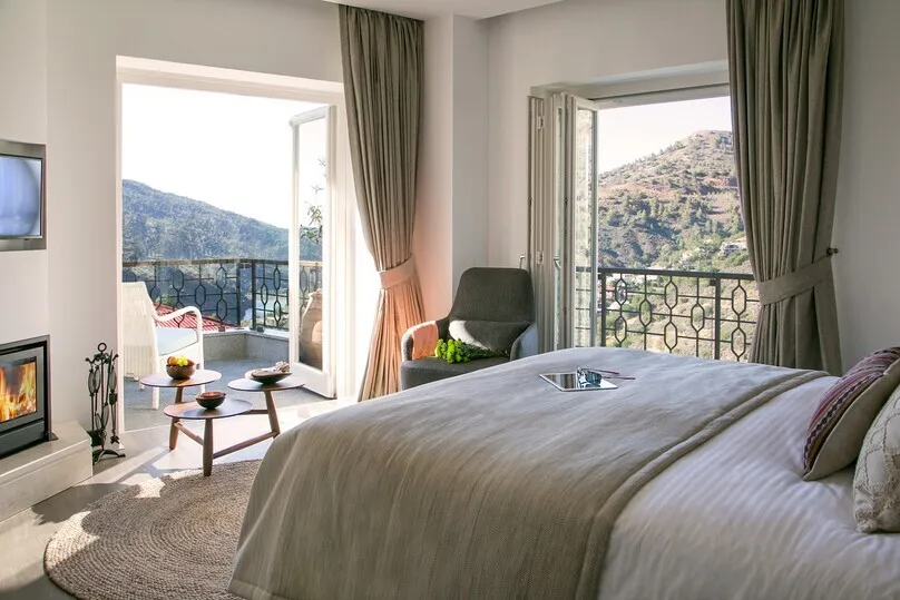 Hotelzimmer mit Doppelbett und Balkon.