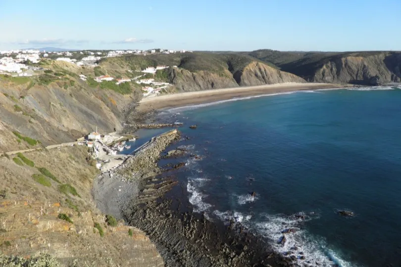 Küstenlandschaft mit felsiger Küste und Sandstrand.
