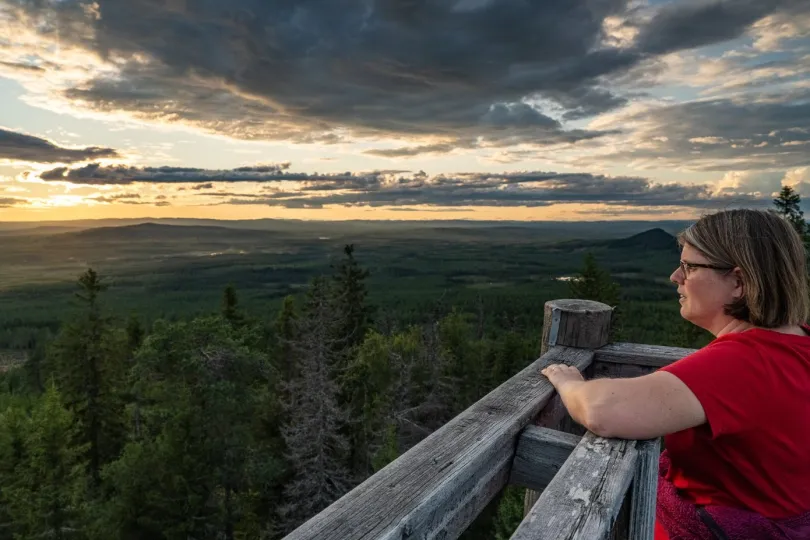 Eine Frau steht in einem Balkin und genießt den Ausblick.