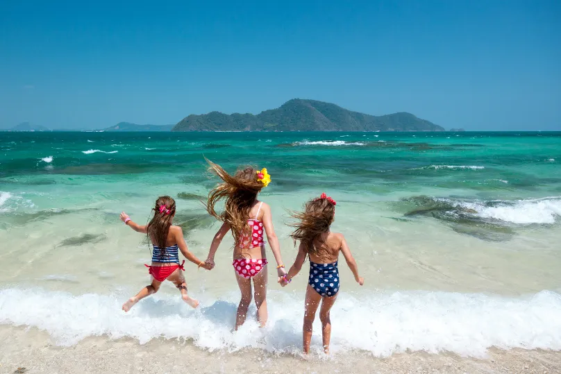 Drei kleine Kinder am Strand.