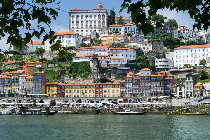 Porto, bunte Häuser an einem Hang am Wasser mit Booten am Ufer.