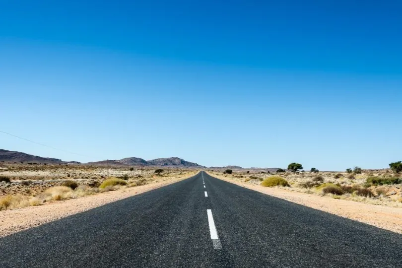 lang gerade straße umgeben mit Wüste.