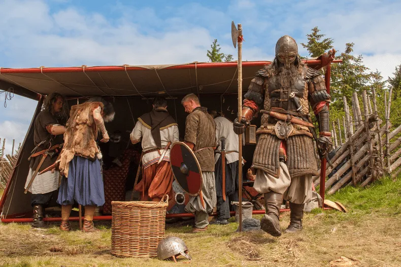 Gruppe von Menschen in mittelalterlicher oder wikingerzeitlicher Kleidung.