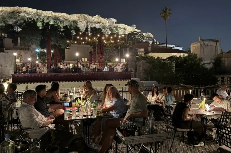 abendliche Szene in einem Außenrestaurant mit Menschen.