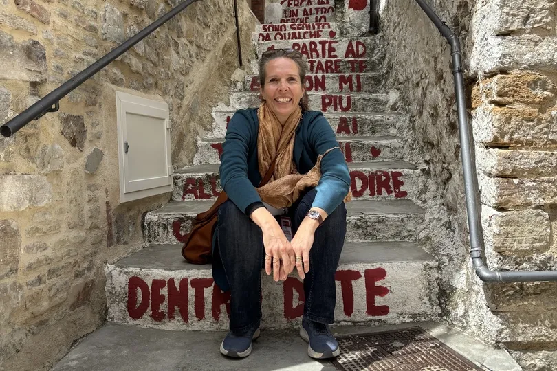 Livia sitzend auf Treppenstufen mit roter Schrift.