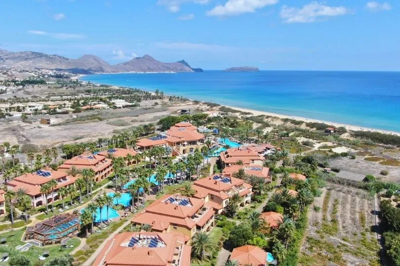 Blick auf einen Badeort, das blaue Meer und viele Apartments.