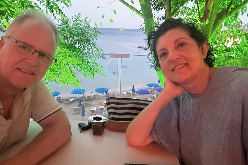 Niki und ihr Ehemann am Tisch mit Ausblick aufs Meer.