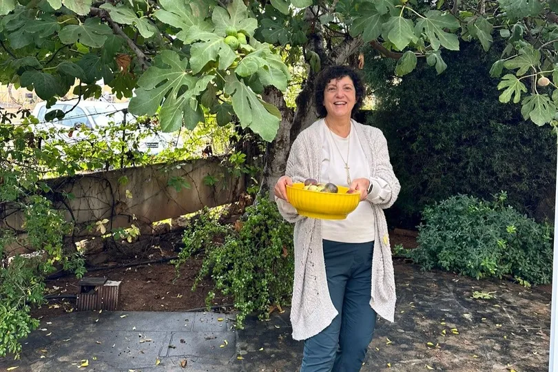Frau mit Obstschale unter einem Feigenbaum.
