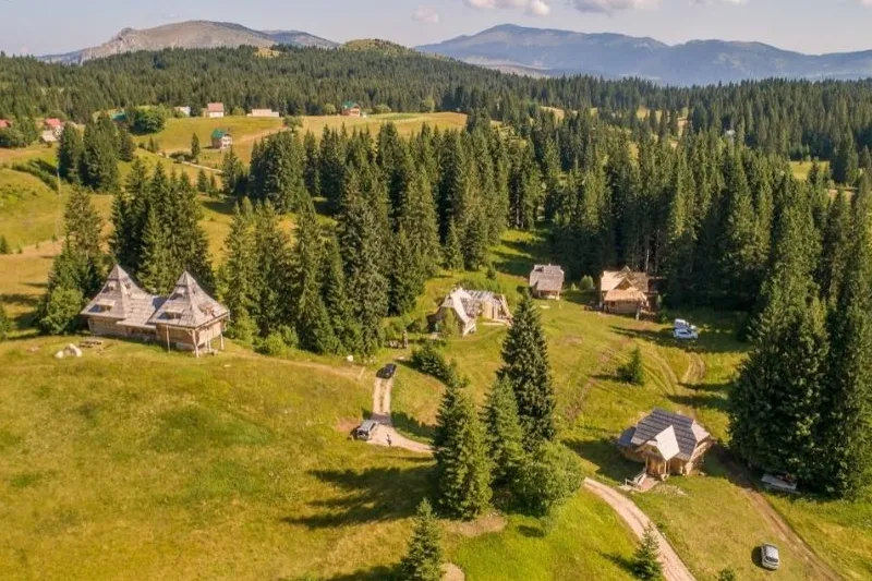 Ein idyllisches Bergdorf im Durmitor-Gebirge mit verstreut liegenden Holzhütten mitten in der Natur.